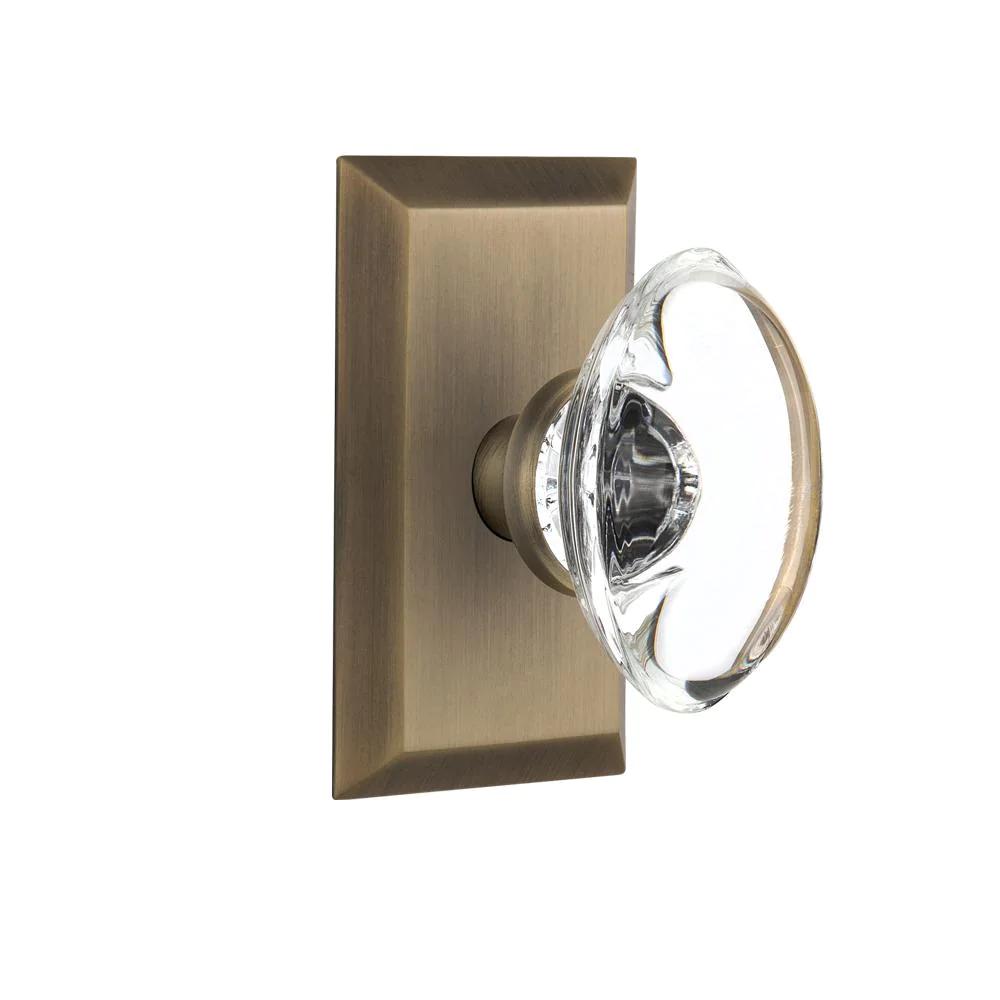 Studio Plate Double Dummy Oval Clear Crystal Glass Door Knob in Antique Brass